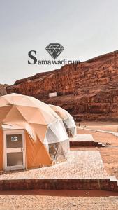 a tent in the desert next to a mountain at Sama Wadi Rum Luxury Camp in Wadi Rum