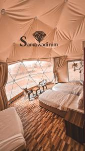 a room with a tent with a bed and a table at Sama Wadi Rum Luxury Camp in Wadi Rum