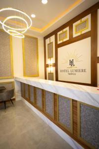 a hotel lobby with a reception counter and a chandelier at Hotel Boutique Lumiere in Tampico