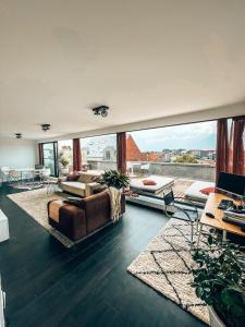ヘールにあるPenthouse with spacious terraces in the heart of Geelのソファと大きな窓のあるリビングルーム