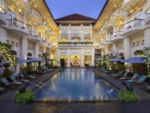 a large building with a swimming pool in the middle at The Phoenix Hotel Yogyakarta - Handwritten Collection in Yogyakarta
