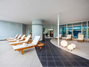 a lobby with a row of chairs and tables at PULLMAN Stuttgart Fontana in Stuttgart