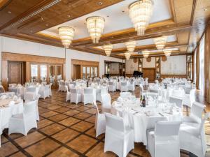 a room with white tables and chairs and chandeliers at PULLMAN Stuttgart Fontana in Stuttgart +92 photos