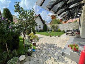 a garden with a patio with a table and a tree at Your Home in Zărneşti
