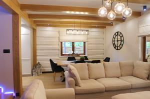 a living room with a couch and a table at Forest Home Dębowa 18 in Łuka
