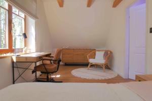 a bedroom with a desk and two chairs and a table at Forest Home Dębowa 18 in Łuka