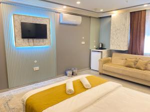 a bedroom with a bed and a tv and a couch at Sahrakent Otel Pendik in Istanbul