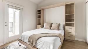 a white bedroom with a large bed and a window at Landing Apartments - Woodburn in Woodburn