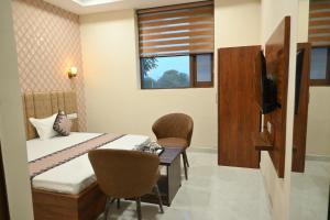 um quarto com uma cama, uma escrivaninha e uma janela em Hotel Lake Casa em Bathinda