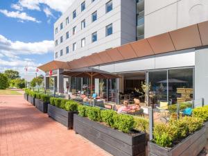 a restaurant with tables and chairs outside of a building at ibis Rotorua in Rotorua