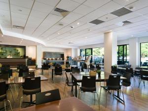 a restaurant with tables and chairs and a bar at ibis Rotorua in Rotorua
