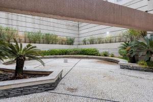a courtyard with a palm tree in a building at Flats Hotel Paulista | Delfhy in São Paulo