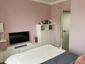 a white room with a tv and a bed at Apartament Kamil in Poznań