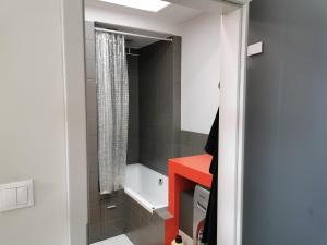 a bathroom with a red counter and a bath tub at Apartament Kamil in Poznań