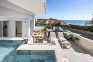 a patio with a table and chairs and the ocean at Casa Milhafre Real in Benagil