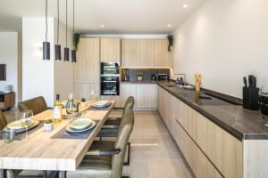 a kitchen with a long wooden table and chairs at Casa Milhafre Real in Benagil