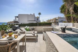 a patio with a table and chairs next to a swimming pool at Casa Milhafre Real in Benagil