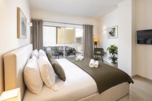 a bedroom with a large white bed with pillows at Casa Milhafre Real in Benagil +30 photos