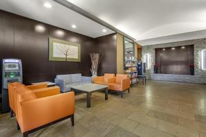 a waiting room with orange chairs and a table at Best Western Plus St Albert in St. Albert