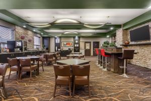 a restaurant with tables and chairs and a bar at Best Western Plus St Albert in St. Albert