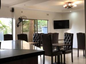a conference room with a table and chairs and a tv at Rosewood Place Lodge in Kitwe