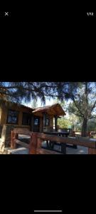 a wooden picnic table in front of a building at El Manik cabañas El Tlayan in Tala