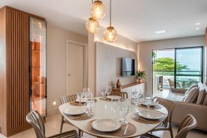 ein Esszimmer mit einem Tisch und Weingläsern darauf in der Unterkunft Apto Praia Barra Grande, Camurim Residence in Maragogi