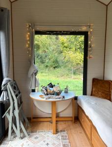 a room with a table and a bed and a window at La Tiny de Mary in Gonneville-sur-Mer +5 photos