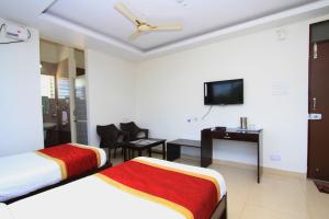 a hotel room with two beds and a desk and a television at Hotel O Sri Sai Residency in Bidadi +10 photos