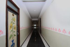 a hallway with a long corridor with pink and white walls at Hotel O Sri Sai Residency in Bidadi