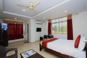 a bedroom with a bed and a bathroom with a ceiling fan at Hotel O Sri Sai Residency in Bidadi