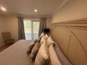 a bedroom with a large bed with pillows and a window at North Conway area 2 bedroom updated condo in Bartlett
