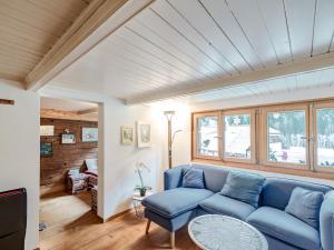a living room with a blue couch and a table at Mys Chalet - Authentique & rénové in Jaun