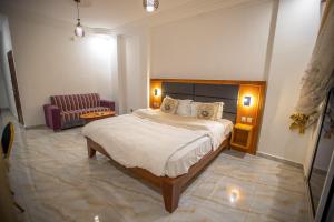 a bedroom with a large bed and a couch at Residence samba in Douala