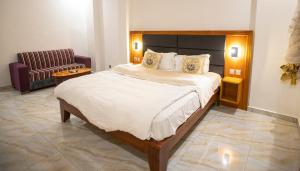 a bedroom with a large bed and a chair at Residence samba in Douala