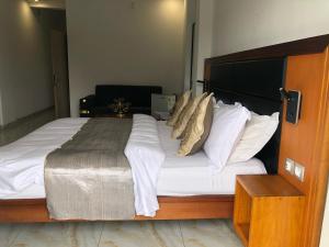 a bedroom with a large bed with white sheets and pillows at Residence samba in Douala