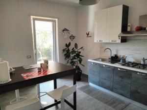 a kitchen with a counter and a table with chairs at Affittacamere Dal Gallo in Staranzano