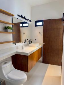 a bathroom with a sink and a toilet and a mirror at Modern beach house in San Carlos in San Carlos