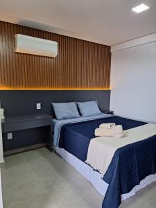 a bedroom with a bed with blue sheets and a white blanket at Apartamento em Granado Convenience in Anápolis