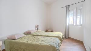 a white bedroom with two beds and a window at Casa Yeye City Loft in Agaete +21 photos