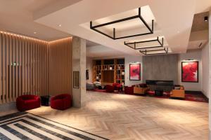 een lobby met rode stoelen en een woonkamer bij The Rose Gaming Resort in Dumfries