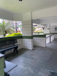 Un baño vacío con un banco en un edificio. en Apto até 6 pessoas -PG Aviação - 150mts e 1 vaga, en Praia Grande