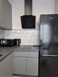a kitchen with a refrigerator and a microwave at Апартаменти на Марсельській 62 в ЖК Острова, 1 спальня та кухня-студія in Odesa