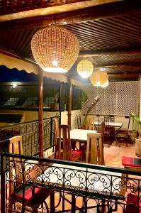 a balcony with a table and chairs and lights at Riad Prada in Marrakech