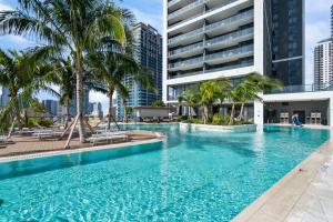 Una gran piscina con palmeras y un edificio. en Luxury experience - views of MIAMI city center, en Miami