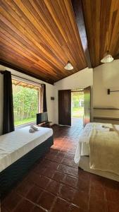 a bedroom with a large bed and a large window at Ibiza in Arraial d'Ajuda