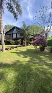 una casa con un patio verde con un árbol en Hosteria Zafiro, en Tigre