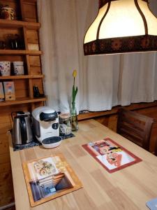a table with a lamp and a coffee maker on it at Lawendowy Domek agroturystyka, noclegi - okolice Bałtowa in Bałtów