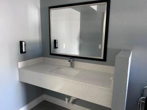 a bathroom with a sink and a mirror at Airport Motor Inn in Jacksonville