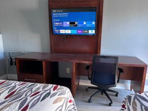 a desk with a computer and a chair in a room at Airport Motor Inn in Jacksonville